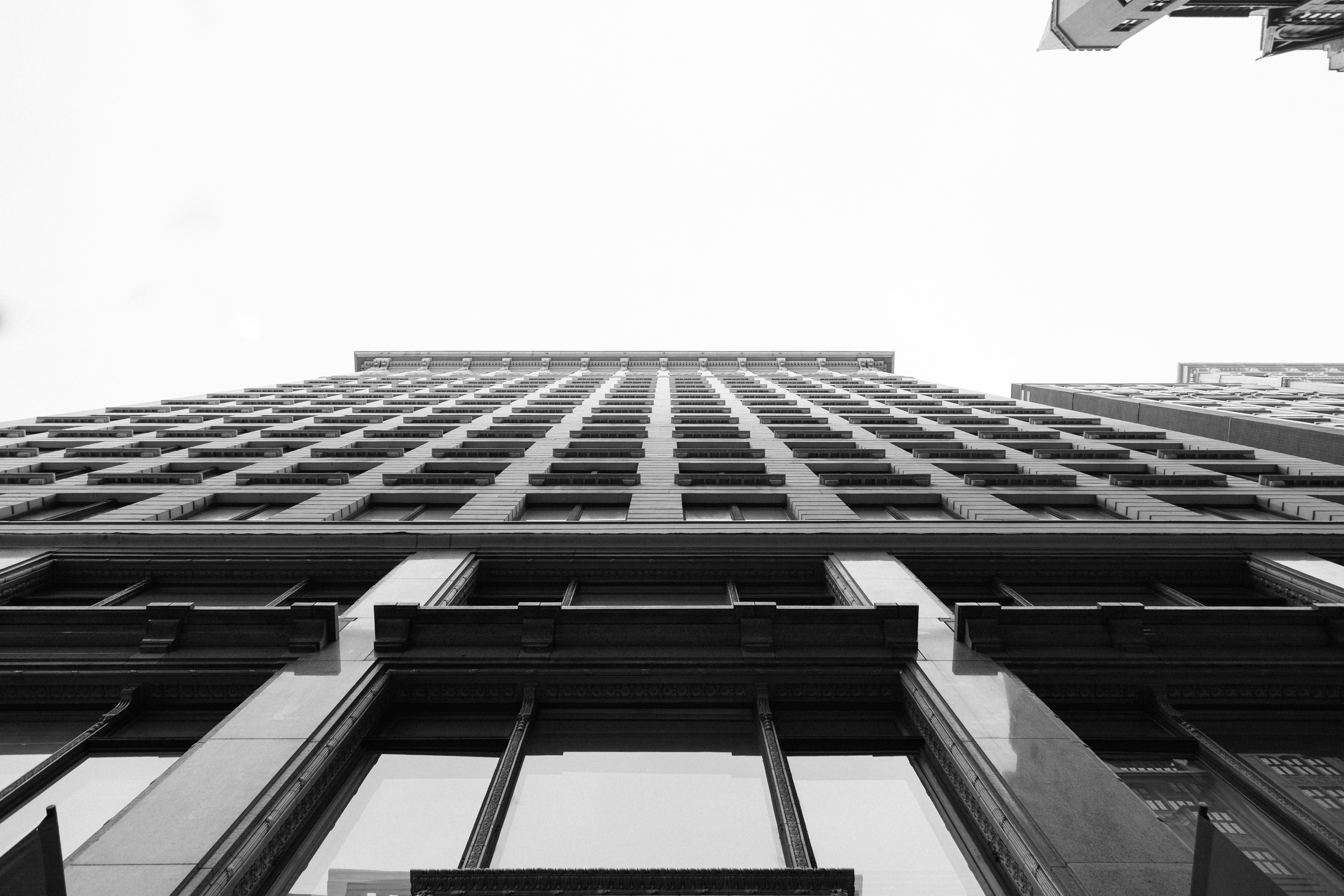 A view up at DePaul university. Looking up at a building, there is a geometric repetition of lines and windows.