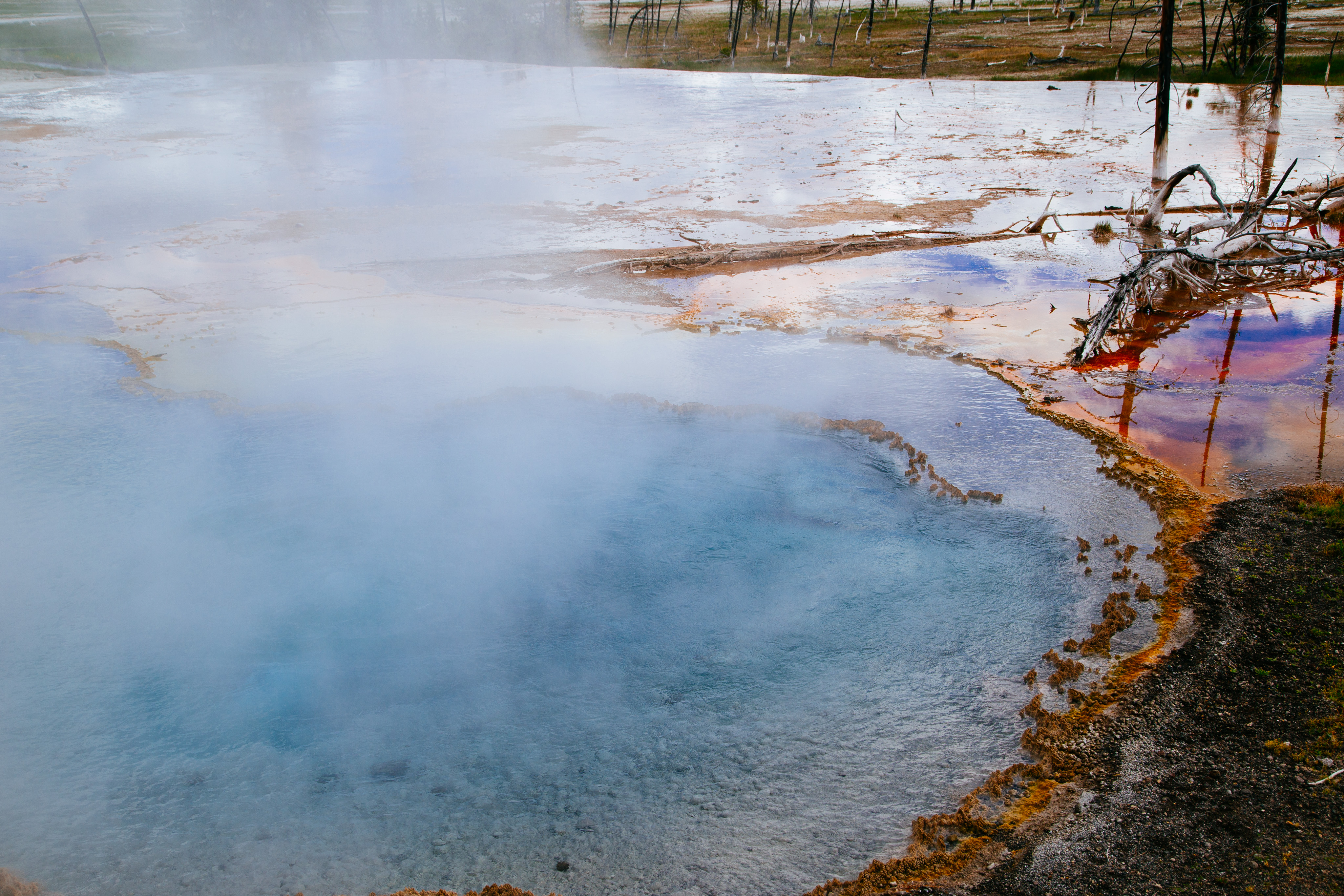 A hot sprints pool with steam rising above multi-colored water.