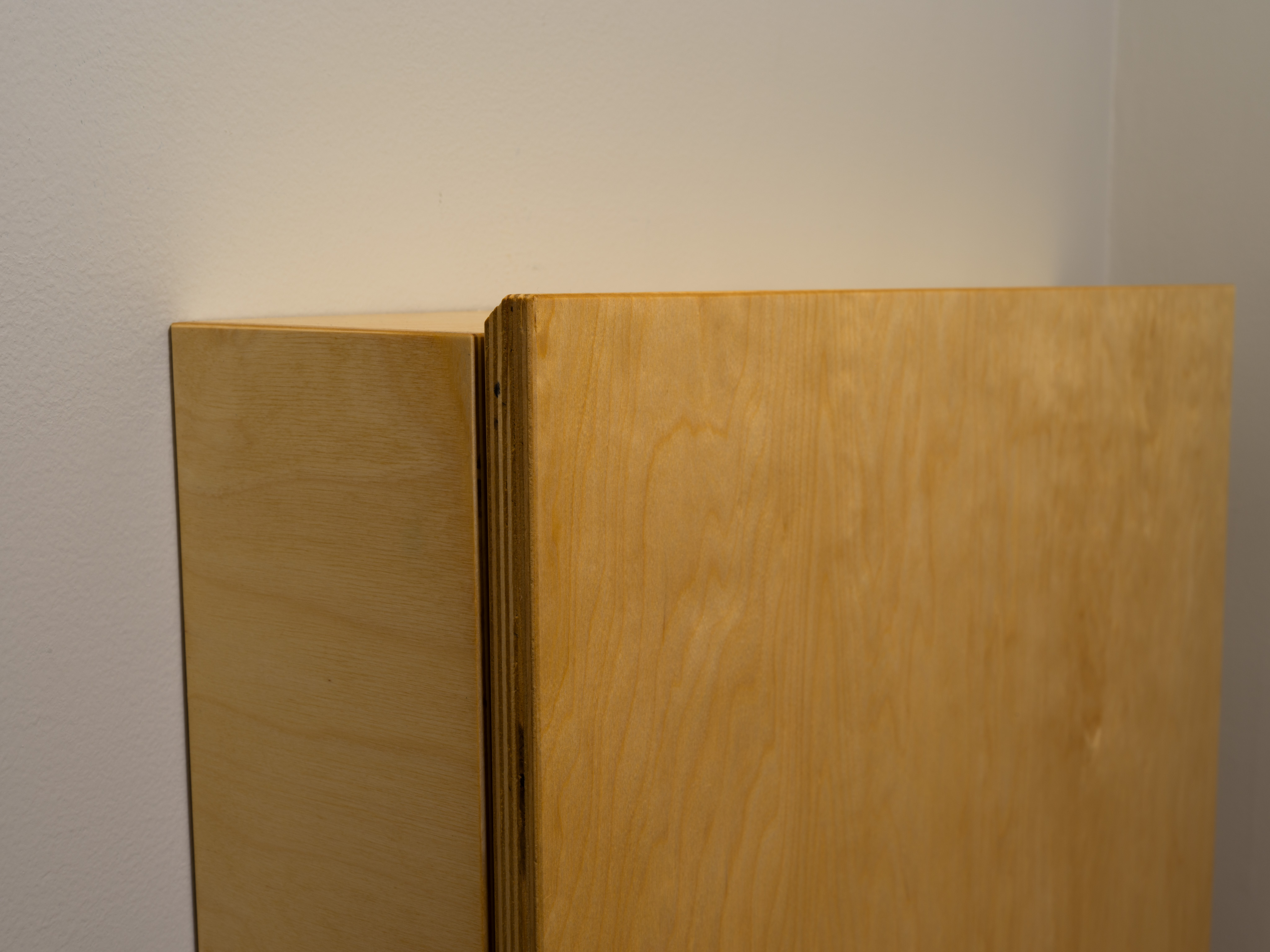 A convertible, fold-down desk. A detail view of the top of the desk portion. I used a 45 degree chamfer on the edge for comfort and as a call back to other pieces that have the same feature. Made from baltic birch.